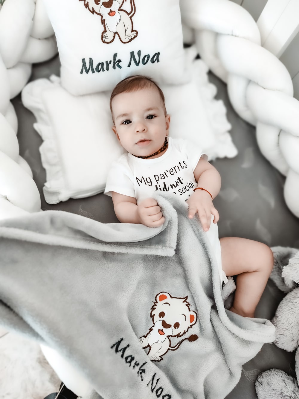 Prekrasni dječačić mirno odmara u svom krevetiću, zagrljen mekanim i ugodnim personaliziranim jastučićem i dekicom, prilagođenim s njegovim imenom i šarmantnim dizajnom.